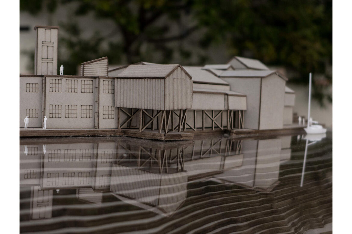 At the edge between the sea and land. Model of original buildings in scale 1:200, seen from the sea.